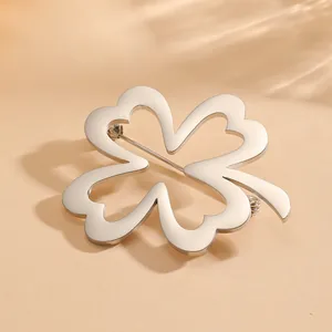 Detailed view of a polished silver titanium steel hollow clover brooch for suits