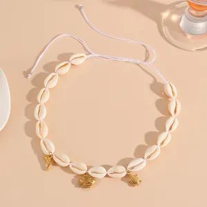 Detailed macro view of cowrie shell necklace with dolphin, fish and turtle charms
