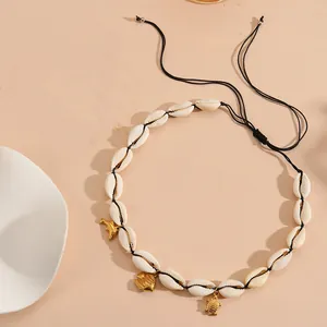 Detailed close-up of natural cowrie shell necklace with golden sea animal charms