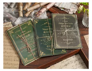 Vista dettagliata di carta vintage con spago, eleganti scritte in oro su copertine scure.