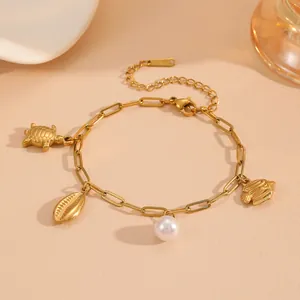 Stainless steel ocean charm pearl bracelet detail, summer beach gold metal jewelry design.
