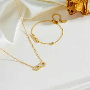 Vue détaillée d'une parure de bijoux collier et bracelet infini dorée avec cristaux