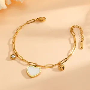 Detail of gold titanium steel bracelet with shell heart and pearl charms