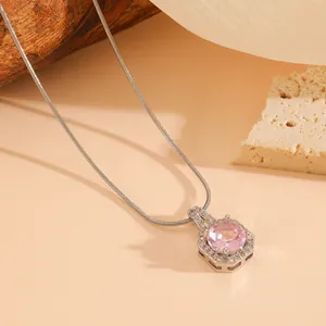 Detail view of pink round gemstone pendant with silver-tone chain necklace