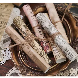 Primo piano di carte da scrapbooking vintage legate con spago in cornice dorata.