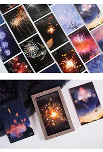 Nahaufnahme von künstlerischen Feuerwerk-Postkarten in einem Holzfotorahmen.