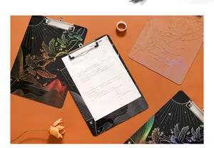 Detail des eleganten lasergoldenen Kranich-Designs auf hochtransparenten Acryl-Klemmbrettern