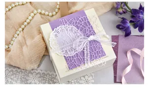 Close-up of vintage-style paper and lace material kit on a decorative gift box.