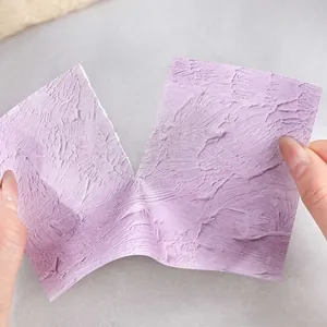 Romantic lavender purple textured craft paper being torn for scrapbooking background