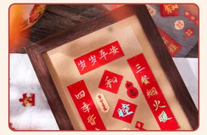 Close-up view of mini red Chinese New Year stickers with gold text in a wooden frame