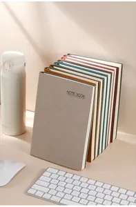 Cuadernos de negocios A5 premium con cubiertas de cuero sintético apilados en un escritorio