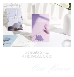 Nahaufnahme einer Postkarte mit japanischem Text und One Flower Typografie-Detail.