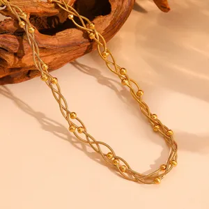 Close-up detail of multi-strand gold braided snake chain necklace with cute round beads.