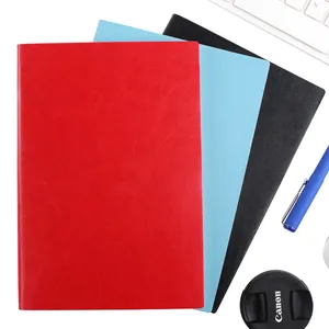 Vue détaillée de cahiers minimalistes en cuir A5 en couleurs rouge, bleu et noir.