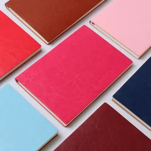 Gros plan d'une collection de carnets A5 en cuir colorés aux textures fines.