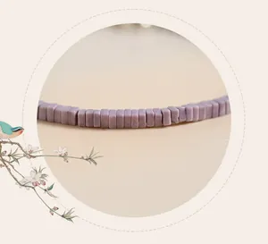Close-up detail of fine purple mica bead bracelet with vintage texture and design.