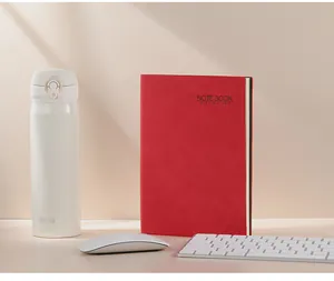 Cuaderno de oficina A5 de cuero nubuck rojo mostrado en un entorno de escritorio profesional