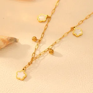 Detailed view of gold-plated titanium steel necklace highlighting white flower and bead charms