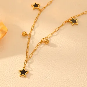 Close-up of titanium steel star pendant necklace with gold beads and black inlay details.