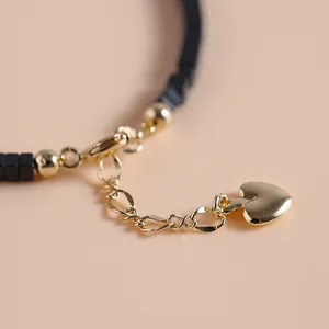 Bracciale vintage in pietra nera con ciondolo a cuore dorato e una chiusura regolabile