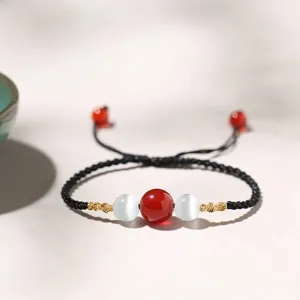 Handcrafted minimalist woven bracelet with red agate and cat eye beads for protection and luck