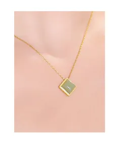 Detailed macro shot of elegant square green Hetian jade pendant on gold silver chain