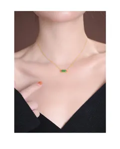 Close-up view of elegant S925 silver gold-plated necklace with green jade pendant on neck