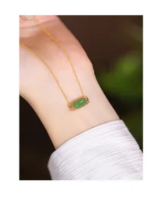 Close-up of elegant S925 silver necklace with green Hetian jade pendant on wrist