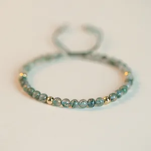 Detailed view of handmade green moss agate beaded bracelet with polished gold spacers