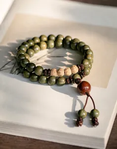 Natural green sandalwood Buddhist bead bracelet with 8mm beads displayed on an open book