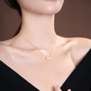 Elegant S925 sterling silver gold necklace featuring a round white jade pendant worn by a model