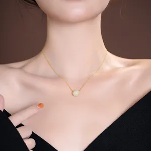 Elegant S925 silver gold-plated necklace with white jade oval pendant worn by model