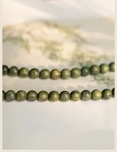 Macro view of high-quality natural green sandalwood prayer beads with fine wood grain