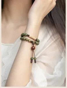 Detail view of a handcrafted green sandalwood bead bracelet on a female wrist, forest style.