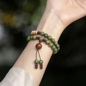 Handcrafted green sandalwood Buddhist bead bracelet with Rudraksha seeds on wrist