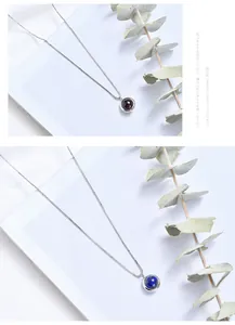 Close-up of minimalist silver necklaces with round garnet and lapis lazuli pendants