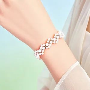 Detailed view of elegant wavy pearl bracelet with high-shine white beads on wrist
