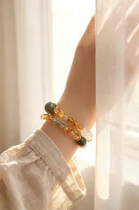 Primer plano de pulsera de citrino natural y cristal blanco Pi Yao en la muñeca