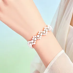 Elegant handcrafted woven pearl bracelet with 14K gold-filled beads on a woman's wrist.