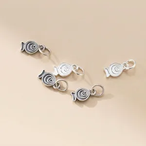 Close-up of 925 sterling silver antique fish pendants with spiral pattern for DIY