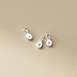 Detailed macro view of S925 sterling silver teardrop charms with star engraving