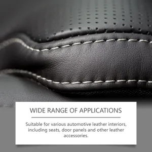 Automotive leather interior detail close-up showing perforated black leather and white stitching.