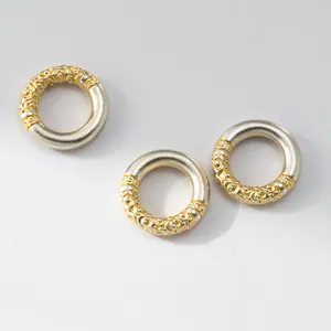 Detalle de tres anillos de plata 999 con patrones Ruyi dorados para la creación de joyas