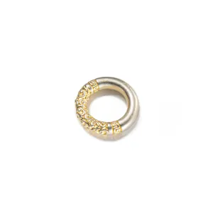 Vista detallada de un anillo de plata 999 con intrincados relieves dorados hechos