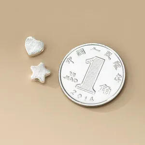 Macro-weergave van 925 sterling zilveren geborstelde hart- en sterrenkralen voor sieraden