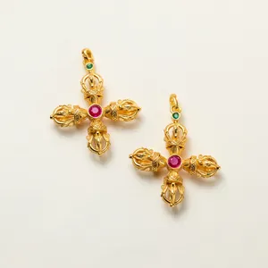 Detailed view of gold-plated 925 silver cross vajra pendants with red corundum stone