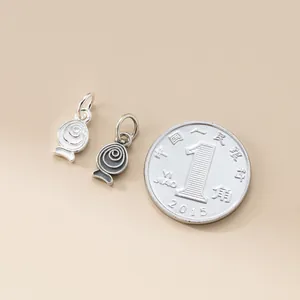 Detailed macro view of small 925 sterling silver fish charms for DIY jewelry making