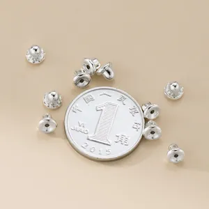 Polierte 925 Sterling Silber Ohrmuttern neben einer Münze für den Größenvergleich