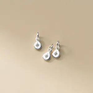Detailed view of 925 sterling silver teardrop charms with starburst stone engraving
