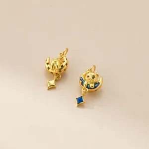 Primo piano di ciondoli a forma di cane 3D placcati in oro con stelle in smalto blu.